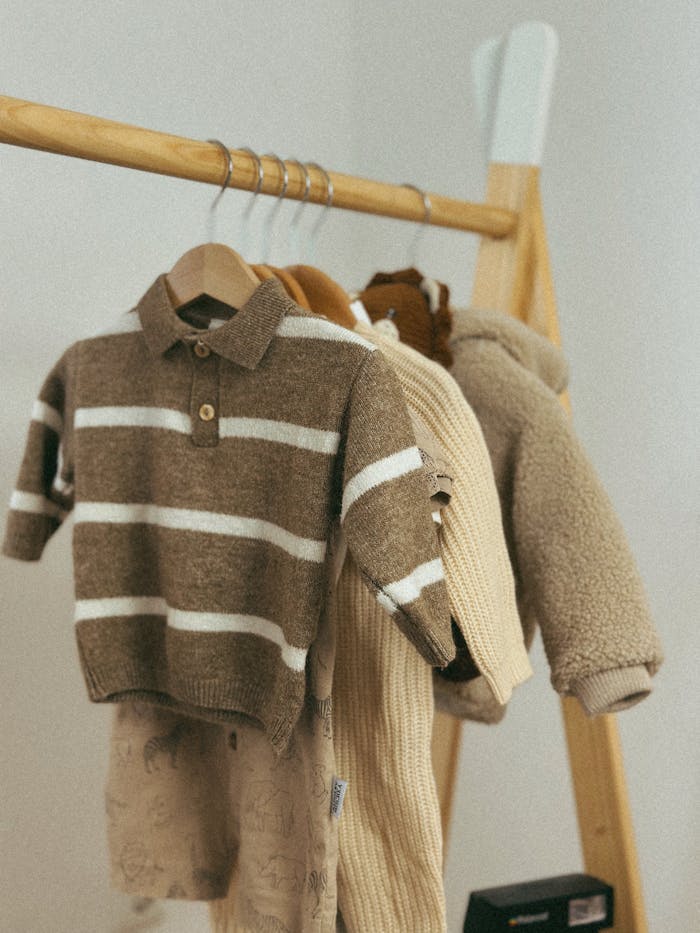 Warm childrens sweaters displayed on a wooden rack, perfect for autumn fashion.